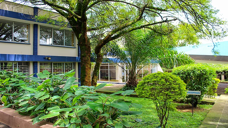 The photograph shows the exterior of the Friedrich Ebert Foundation (FES) office in Kampala, Uganda. It is surrounded by a small, well-kept garden.
